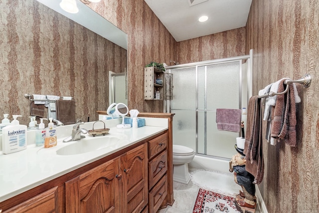 bathroom featuring tile patterned floors, toilet, a shower with door, wallpapered walls, and vanity