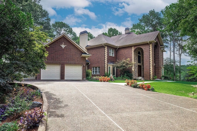 view of front of house featuring brick siding, driveway, a chimney, and a front lawn