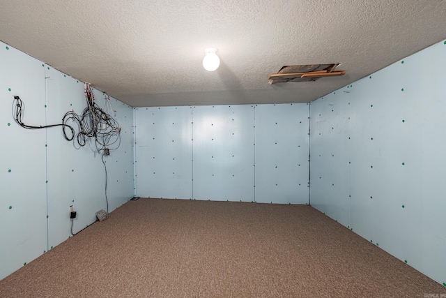 empty room with carpet floors and a textured ceiling