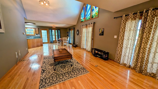 dining space with vaulted ceiling, light hardwood / wood-style flooring, sink, and french doors