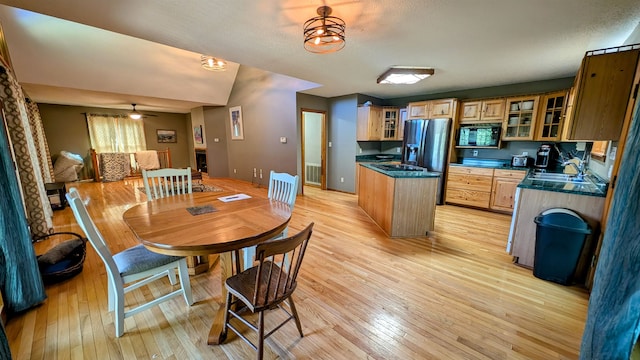 dining space featuring ceiling fan, sink, and light hardwood / wood-style flooring