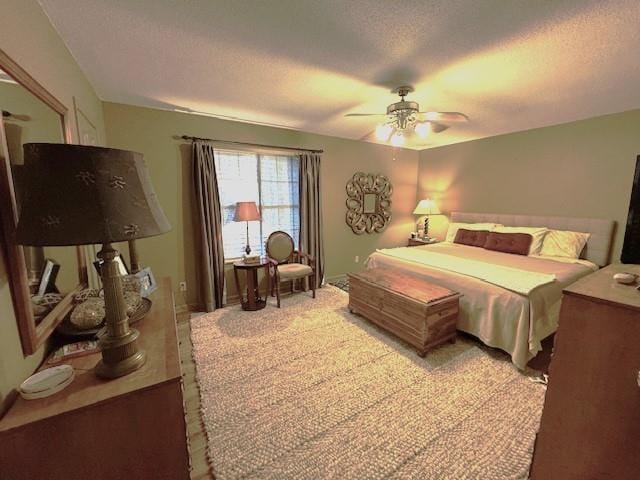 carpeted bedroom with ceiling fan and a textured ceiling