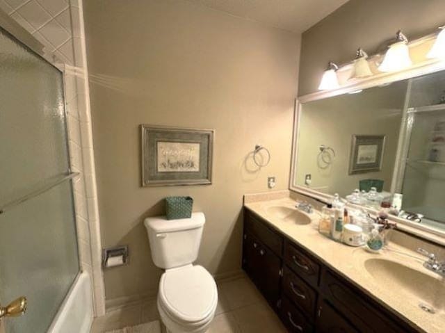 full bathroom featuring toilet, vanity, shower / bath combination with glass door, and tile patterned flooring