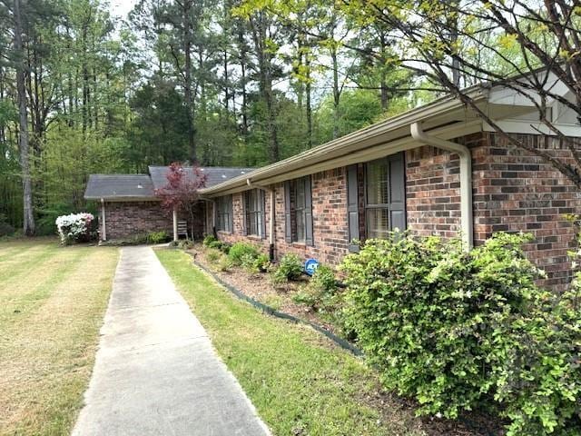 view of side of home with a yard