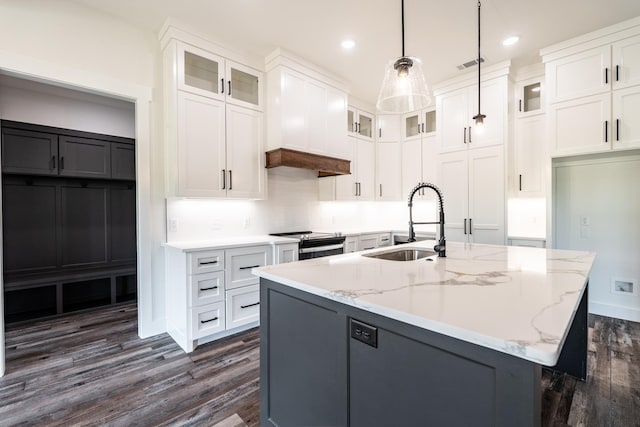 kitchen with sink, decorative light fixtures, a center island with sink, light stone countertops, and white cabinets