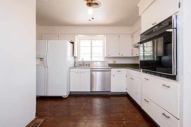 kitchen with white cabinets, a sink, white refrigerator with ice dispenser, black oven, and stainless steel dishwasher