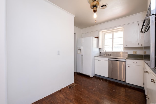 kitchen featuring visible vents, crown molding, white refrigerator with ice dispenser, dishwasher, and a sink