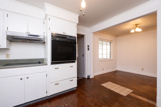 kitchen with dark wood-type flooring, ornamental molding, under cabinet range hood, and black appliances