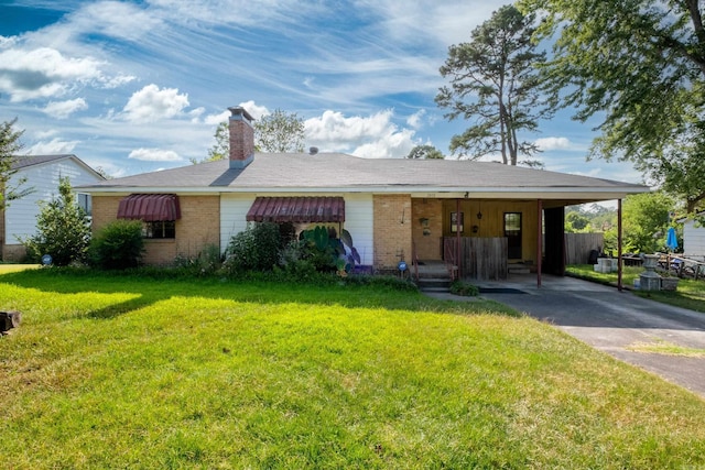 ranch-style home with a front lawn, a chimney, an attached carport, brick siding, and driveway