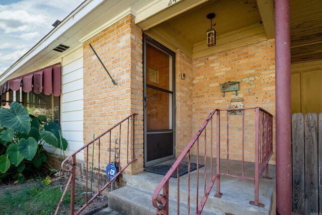 property entrance featuring brick siding