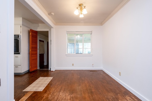 unfurnished dining area with visible vents, ornamental molding, dark wood-style flooring, baseboards, and a chandelier