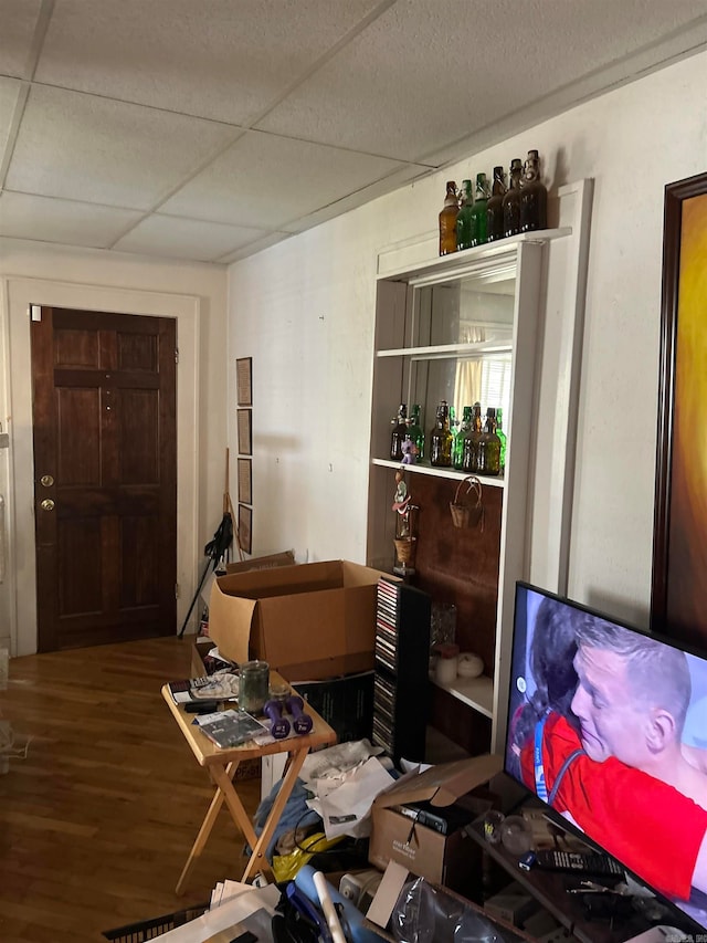 miscellaneous room with a drop ceiling and hardwood / wood-style flooring