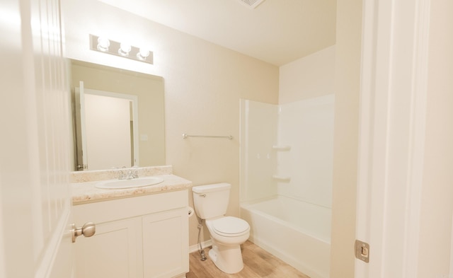 full bathroom featuring toilet, hardwood / wood-style floors, vanity, and shower / tub combination