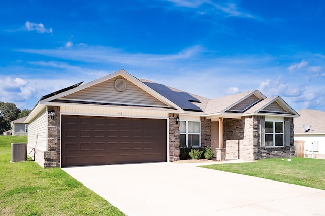 view of front of house with a front yard, a garage, and solar panels