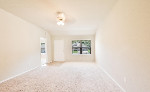 carpeted spare room featuring ceiling fan and vaulted ceiling