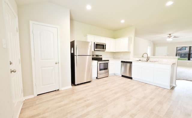 kitchen featuring ceiling fan, stainless steel appliances, white cabinets, light wood-type flooring, and sink