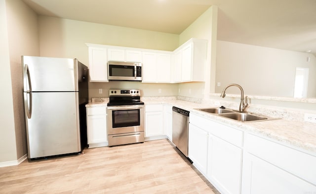 kitchen featuring sink, appliances with stainless steel finishes, light wood-type flooring, and white cabinets