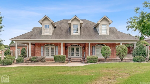 new england style home with covered porch and a front lawn