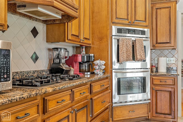 kitchen with appliances with stainless steel finishes, premium range hood, and tasteful backsplash