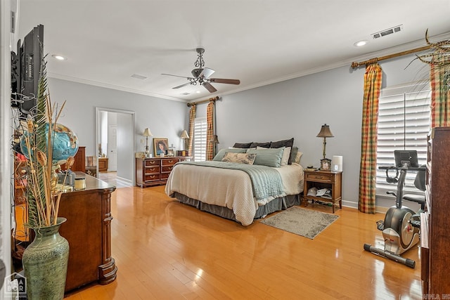 bedroom with light hardwood / wood-style flooring, ornamental molding, and ceiling fan