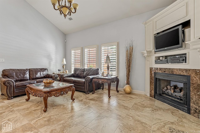 living room featuring a notable chandelier, a premium fireplace, light tile patterned floors, and high vaulted ceiling