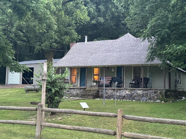 view of front of property featuring a garage, a front lawn, and covered porch