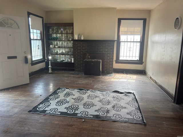 unfurnished living room featuring a fireplace, hardwood / wood-style floors, and a healthy amount of sunlight