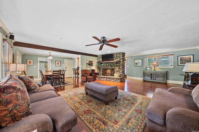 living area featuring a textured ceiling, a fireplace, crown molding, and wood finished floors