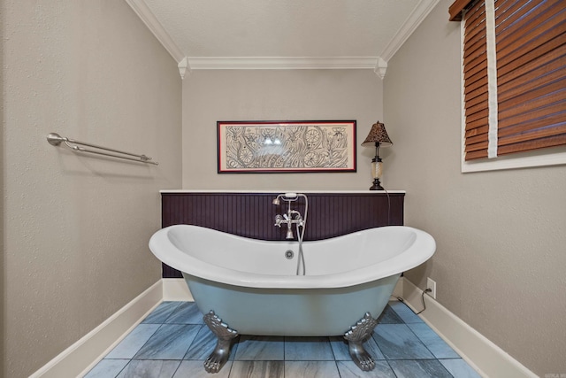 full bathroom with crown molding, baseboards, and a freestanding bath