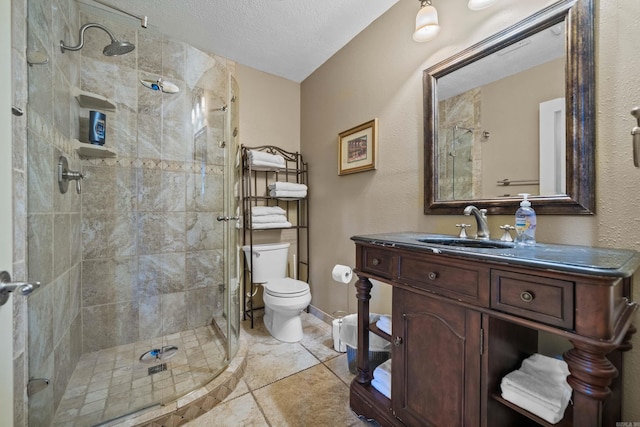 full bathroom featuring a textured ceiling, toilet, vanity, baseboards, and a shower stall