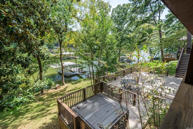 wooden terrace with a yard and a water view