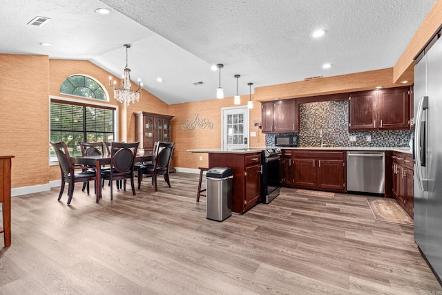 kitchen featuring hanging light fixtures, a chandelier, light hardwood / wood-style flooring, and stainless steel appliances