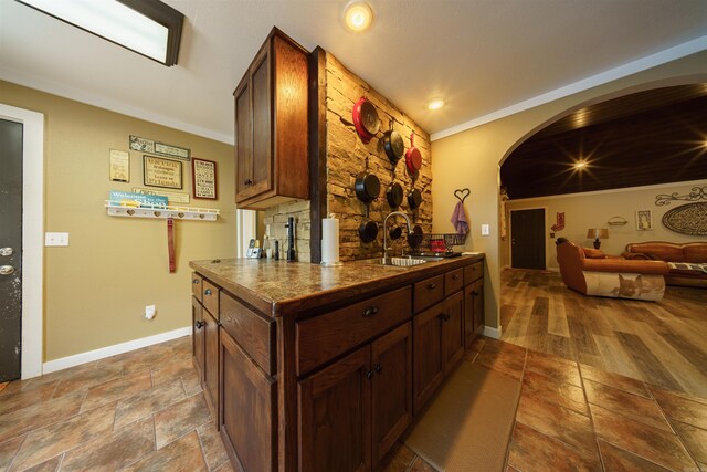 kitchen with ornamental molding, sink, kitchen peninsula, and light hardwood / wood-style floors