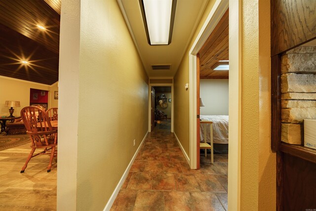 corridor featuring tile patterned floors, vaulted ceiling, and wood ceiling