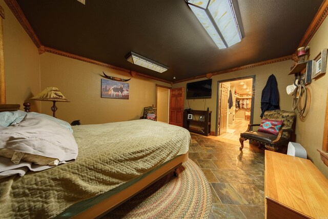 tiled bedroom featuring a skylight and ornamental molding