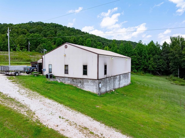 exterior space with cooling unit and a yard