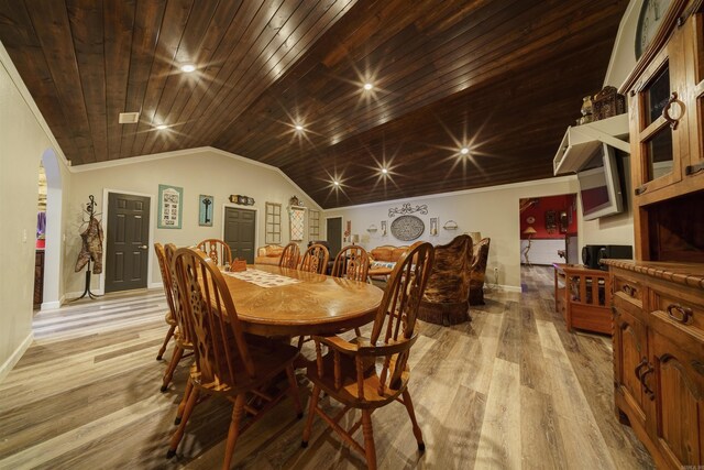 dining room with ornamental molding, vaulted ceiling, wooden ceiling, and light wood-type flooring