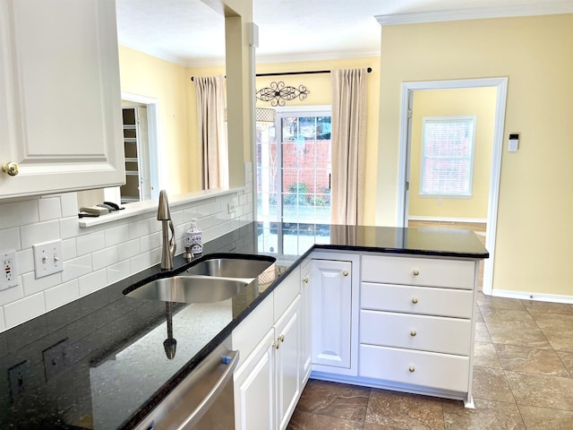 kitchen featuring sink, tasteful backsplash, dark stone countertops, kitchen peninsula, and white cabinets