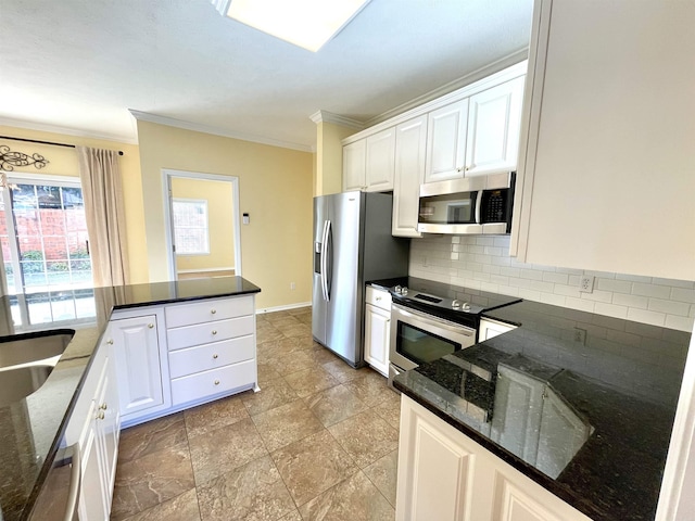 kitchen with white cabinetry, dark stone countertops, ornamental molding, appliances with stainless steel finishes, and decorative backsplash