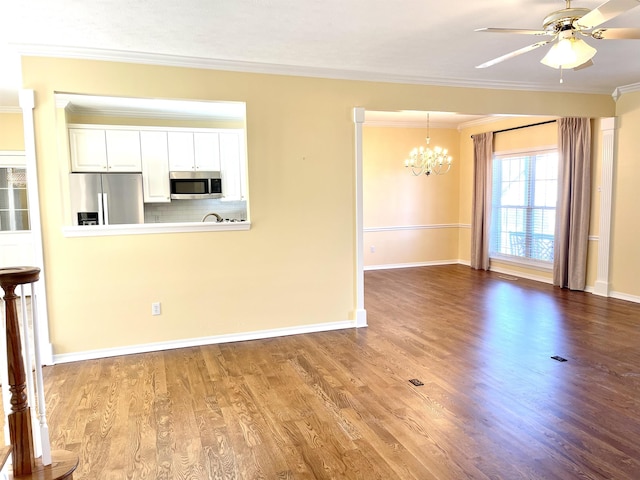 unfurnished living room featuring hardwood / wood-style flooring, ornamental molding, and ceiling fan with notable chandelier