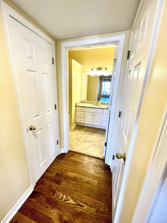 corridor featuring sink and dark hardwood / wood-style floors