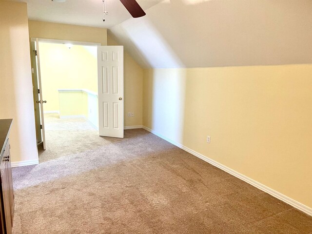 additional living space featuring ceiling fan, carpet floors, and vaulted ceiling