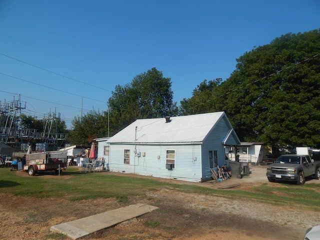 view of side of property with a yard and an outbuilding