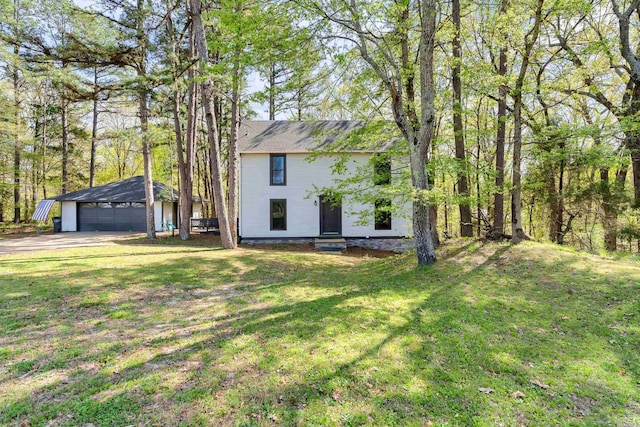 view of front facade featuring an outdoor structure, a garage, and a front lawn