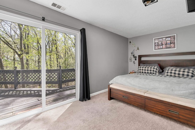 carpeted bedroom with access to exterior and a textured ceiling