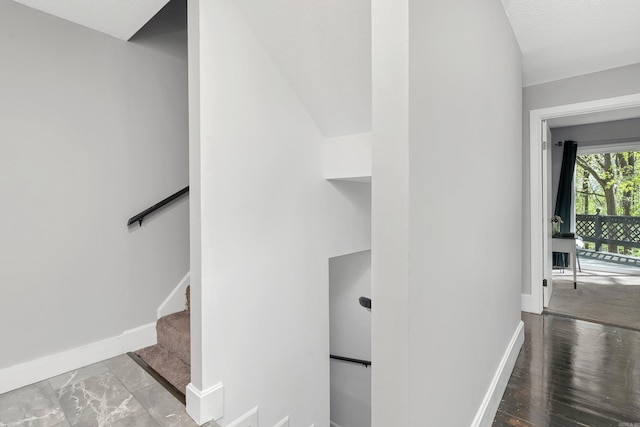 hallway with hardwood / wood-style flooring and lofted ceiling