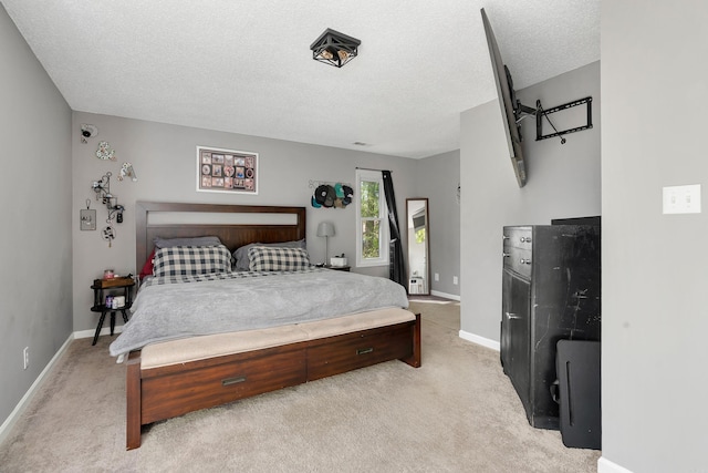 bedroom featuring light carpet and a textured ceiling