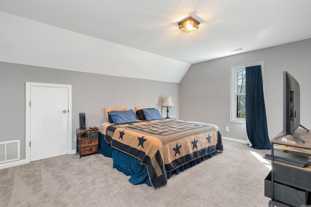 carpeted bedroom featuring a textured ceiling and vaulted ceiling