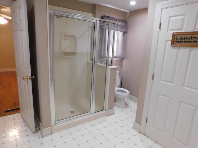 bathroom with a shower with shower door and toilet