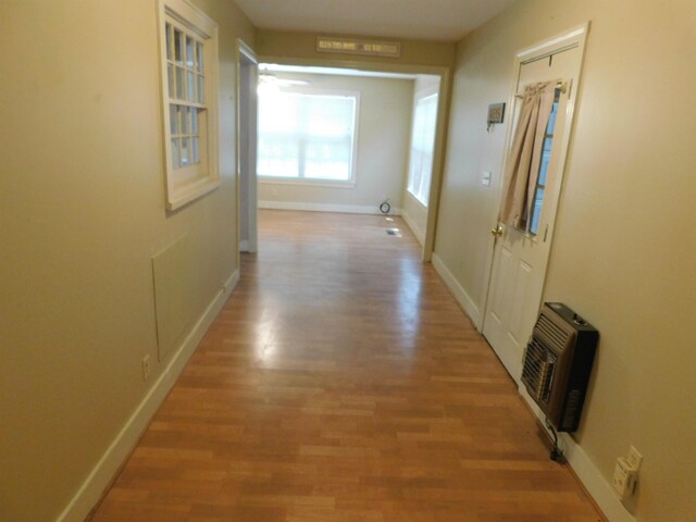 hallway featuring heating unit and light hardwood / wood-style floors